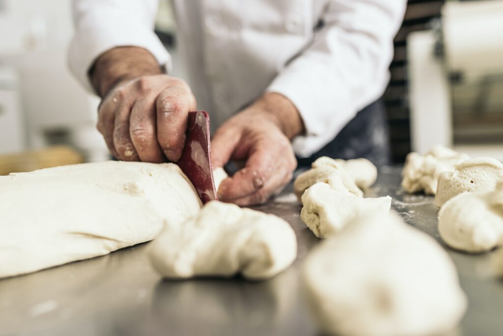 Baker kneading dough in a bakery.