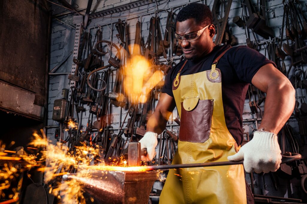 Dans notre société actuelle, l'art de la ferronnerie est un métier de plus en plus prisé et apprécié pour son travail du métal, qui allie à la fois force et finesse. En effet, les ferronniers sont d'habiles artisans qui maîtrisent le travail du fer et du métal de manière exceptionnelle, pour créer des pièces uniques et raffinées, tant pour les constructions métalliques que pour la décoration intérieure.

Dans cet article, nous vous proposons de plonger dans l'univers de la ferronnerie, son histoire, ses techniques, ainsi que les métiers et formations qui en découlent. Nous aborderons également les perspectives d'emploi et les différentes possibilités de carrière dans ce domaine passionnant.

L'histoire et les techniques de la ferronnerie

La ferronnerie est un art millénaire qui remonte à l'époque de la Grèce antique, où les premières créations en fer forgé ont vu le jour. En France, la ferronnerie a connu un véritable essor au Moyen Âge, avec la construction de nombreux édifices religieux pour lesquels les ferronniers ont réalisé des ouvrages d'une grande finesse et d'une grande beauté.

Travail du fer chaud

Le travail à la forge

Le travail du ferronnier se déroule principalement à la forge, un lieu où l'artisan chauffe le métal pour le rendre malléable et le travailler avec aisance. La forge est équipée d'une multitude d'outils tels que l'enclume, le marteau et les tenailles, indispensables pour maîtriser la matière et lui donner la forme souhaitée. Le métal est frappé à chaud sur l'enclume à l'aide du marteau pour être façonné selon les besoins et les envies du ferronnier. Les coups de marteau sont ajustés avec précision pour obtenir une finition parfaite et une durée de vie optimale des pièces réalisées.

La fonte à cire perdue

La technique de la fonte à cire perdue consiste à réaliser un modèle en cire, qui sera ensuite recouvert d'un moule réfractaire. Lorsque la cire est fondue et évacuée, le métal en fusion est coulé dans le moule, qui est ensuite cassé pour récupérer la pièce obtenue. Cette méthode permet de réaliser des pièces complexes et très détaillées, au plus près des attentes du ferronnier.

Les métiers et formations de la ferronnerie

Le travail du métal offre de nombreuses perspectives de carrière, pour des métiers variés et passionnants. De la forge à la construction métallique, en passant par la décoration intérieure, les possibilités sont nombreuses pour ceux qui souhaitent se lancer dans l'aventure de la ferronnerie.

Le forgeron ferronnier

Le forgeron ferronnier est un artisan spécialisé dans la réalisation d'ouvrages en fer forgé, tels que des grilles, des balcons, des rampes d'escalier ou des objets décoratifs pour la maison. Son travail se concentre sur la mise en forme du métal à chaud, en utilisant les techniques de la forge et du martelage.

Pour exercer ce métier, il est nécessaire de suivre une formation adaptée, telle que le CAP Ferronnerie d'Art ou encore le Brevet Professionnel (BP) Ferronnier. Ces formations permettent d'acquérir les compétences techniques et artistiques nécessaires pour exercer ce métier avec brio.

Le serrurier métallier

Le serrurier métallier est un professionnel qui travaille principalement sur les structures métalliques pour la construction de bâtiments, la réalisation de portails, de clôtures, et de mobilier urbain. Il est également amené à travailler sur des projets de décoration intérieure, en collaboration avec des architectes ou des décorateurs d'intérieur.

Pour devenir serrurier métallier, il est possible de suivre des formations telles que le CAP Serrurier Métallier, ou encore le Bac professionnel Ouvrages du bâtiment : Métallerie. Ces formations permettent d'acquérir les compétences techniques nécessaires pour maîtriser les différents types de métaux et les techniques de travail du métal.

Les perspectives d'emploi et les opportunités de carrière

Les offres d'emploi dans le domaine de la ferronnerie sont variées et intéressantes pour les personnes passionnées par le travail du métal et souhaitant s'investir dans un métier d'art. De nombreux emplois sont à pourvoir chez les artisans ferronniers, les entreprises de construction métallique, ainsi que les ateliers de décoration intérieure.

Avec de l'expérience, il est également possible de se lancer à son compte en tant qu'artisan ferronnier indépendant, et ainsi donner vie à ses propres créations et travailler en étroite collaboration avec ses clients.

L'art de la ferronnerie est un métier passionnant qui demande une grande maîtrise du travail du métal et une créativité sans limite. Les ferronniers et les serruriers métalliers sont des artisans précieux qui mettent leur savoir-faire et leur talent au service de la beauté et de la durabilité des ouvrages qu'ils réalisent.

Si vous êtes intéressé par ce métier et souhaitez vous lancer dans une carrière riche en opportunités, n'hésitez pas à vous renseigner sur les formations disponibles et à vous rapprocher des professionnels du secteur pour en apprendre davantage sur cet univers fascinant.