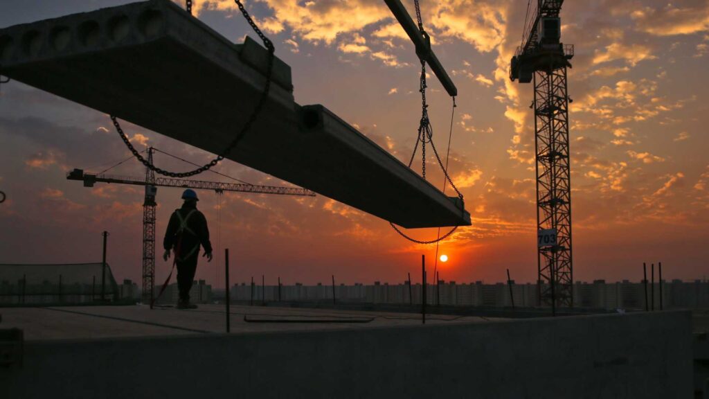 Ouvrier du bâtiment sur un chantier au couché de soleil